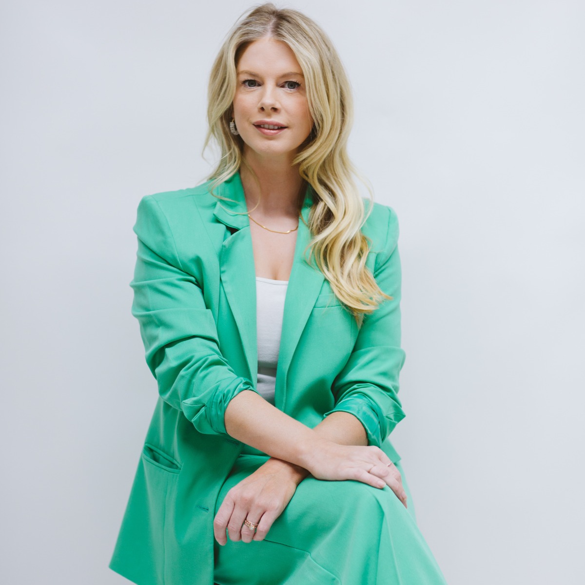 Beth Clay seated in a green suit